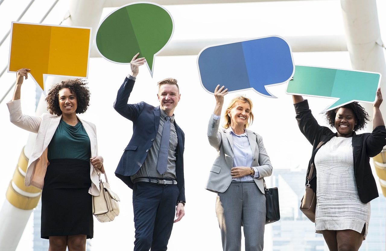 Business people holding up dialogue clouds