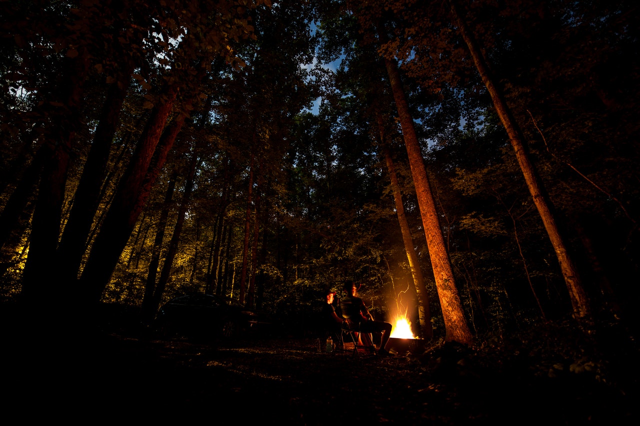 Sitting by a camp fire in the woods